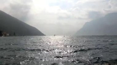 İtalya 'nın Torbole kentindeki Garda Gölü' nde rüzgar sörfü yapan insanlar