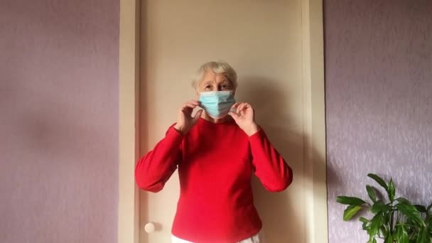 Mujer Mayor Sonriente Positiva Quita Máscara Médica Protectora Cara Casa — Vídeo de stock
