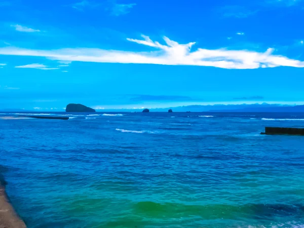 インドネシア バリ出身 火山のGunung Agungは バリ島の東海岸にあるこの小さな漁村の黒い砂のビーチを波が破るので 地平線を支配しています — ストック写真
