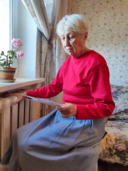 Gaz Faturasını Kaloriferin Önünde Tutan Yaşlı Kadın Kışın Isıtma Için — Stok fotoğraf