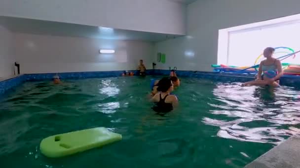 乌克兰基辅 2020年8月29日 可爱的小男孩穿着泳衣踢脚 戴着泳镜 用浮板学习在室内游泳池游泳 — 图库视频影像