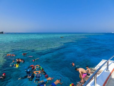 Sharm El Sheikh, Mısır - 10 Eylül 2020: Bir grup turist 10 Eylül 2020 tarihinde Mısır 'ın Sharm El Sheikh kentindeki eğlence teknelerinin yakınında Kızıl Deniz' de yüzüyorlar. Açık denizde şnorkelle yüzmek. İnsanlar geminin yanında yüzüyor..