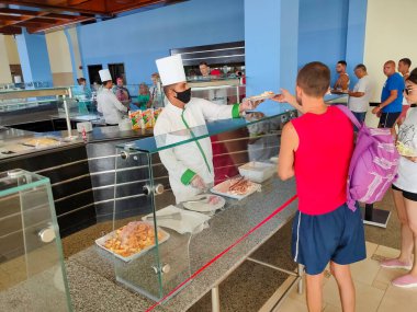 Sharm El Sheikh, Mısır - 14 Eylül 2020: Koruyucu maskeli garson Sharm El Sheikh, Mısır 'daki Hotel Siva Sharm' da yemek servisi yapıyor 14 Eylül 2020.