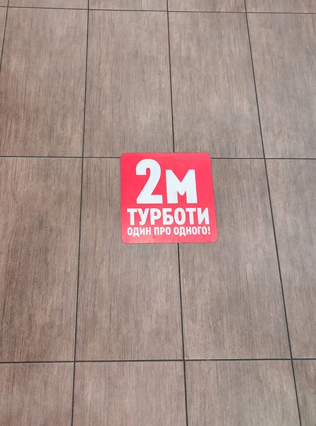 Ukrayna karantinada. Yerdeki yazıtlar -2 metre birbirinize dikkat edin ya da mesafenizi koruyun, burada durmayın. Covid-19 veya koronavirüs konsepti