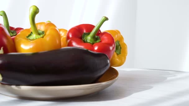 Gekleurde rode gele paprika en aubergine Placed op plaat — Stockvideo