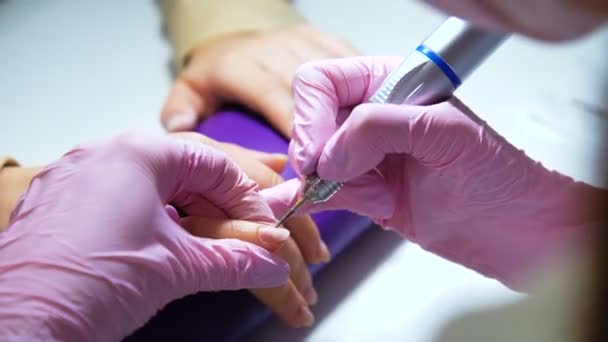 Kosmetolog noggrann och omsorgsfull ta bort nagelbanden med polska maskin — Stockvideo