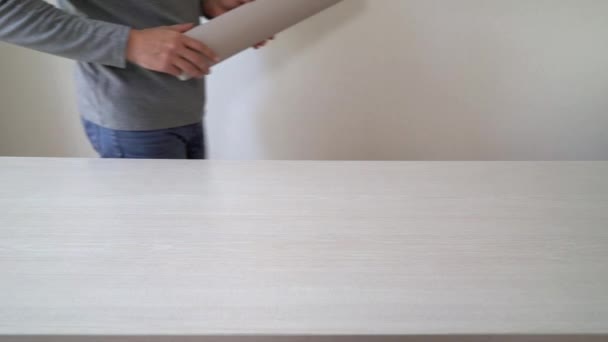室内のテーブルの上のマーキングの新しい壁紙のロールを準備便利屋 — ストック動画