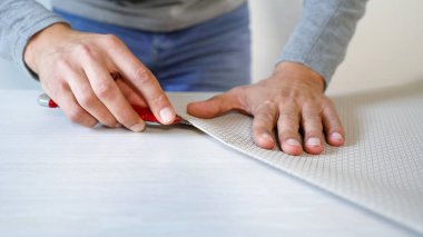 Erkek eller hazırlanıyor yeni bükümlü duvar kağıdı ileti örneği bıçakla masada kapalı rulo