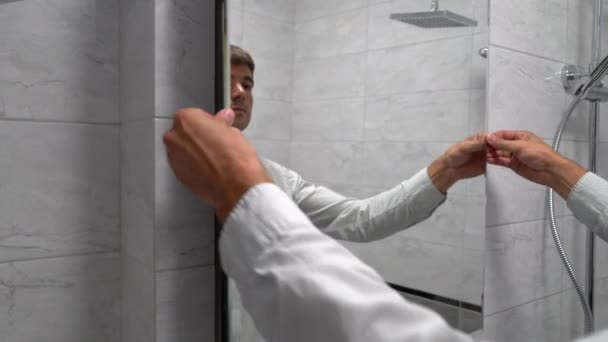 Молодой кавказский человек открыл зеркальную дверь и перекрыл главный клапан холодного водоснабжения — стоковое видео