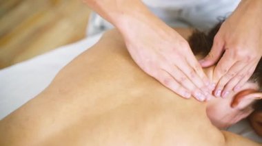 Erkek masör Masaj spa merkezi closeup tabloda boynunda güzel genç kadın.