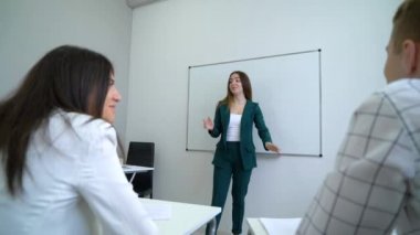 Üniversite öğrencileri sınıfta koçluk beyaz tahta yakınındaki Genç beyaz öğretmen