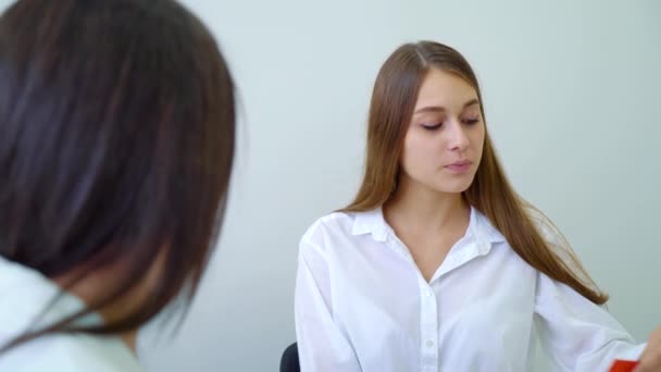 Junge Studentinnen nehmen Farbkarten in die Hand und diskutieren im Klassenzimmer der High School über Aufgaben — Stockvideo