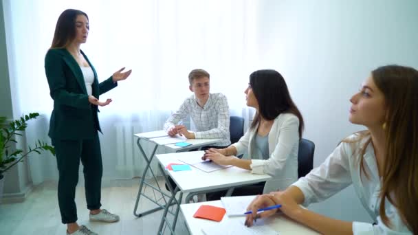 Genç öğretmen öğrencilerle tartışmak ve takım çalışması becerileri birlikte sınıfta eğitim — Stok video