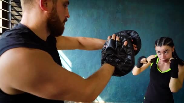 Fitte weiße Boxerin beim Training mit Boxtrainer im Fitnessstudio. — Stockvideo