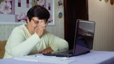 Kıdemli yaşlı kadın evde laptop günlük masraflar kontrol gözlük