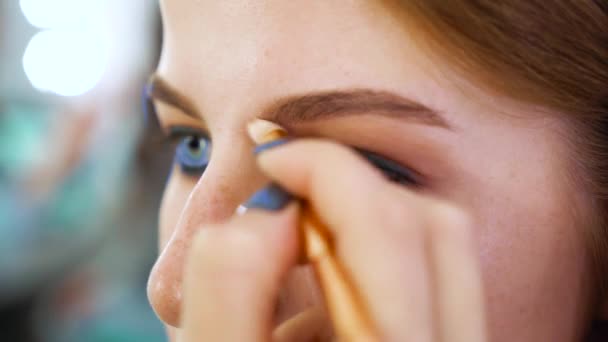 Primer plano atractiva mujer joven conseguir maquillaje profesional en el salón de belleza — Vídeo de stock