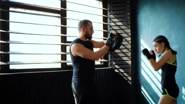 Entrenamiento de boxeador femenino blanco en forma con entrenador de boxeo en el gimnasio . — Vídeo de stock