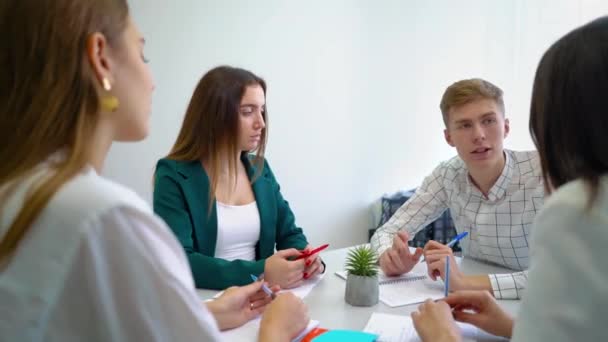 Férfi és női főiskolai hallgatók miután csapatmunka gyakorlat asztalnál. — Stock videók