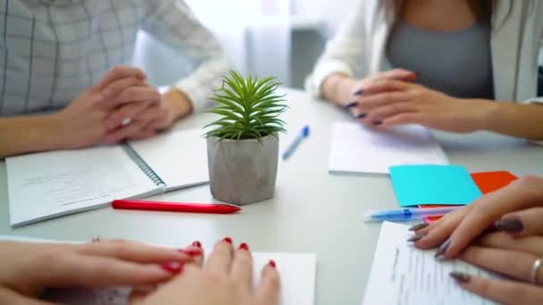 Closeup jongen en meisjes student handen met pennen en notitieboekjes op tafel — Stockvideo