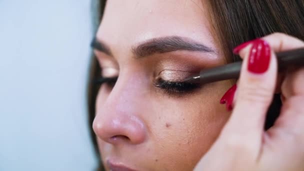 Zbliżenie widok kobiecych rąk zastosowanie eyeliner na powieki młodych atrakcyjnych womans — Wideo stockowe