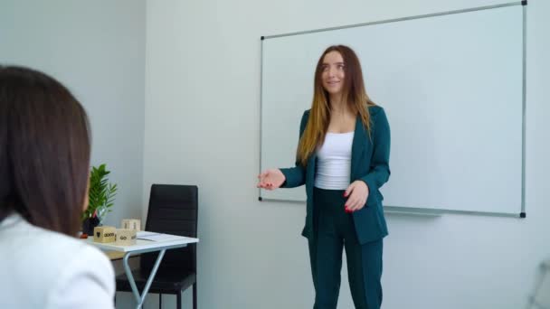 Profesora joven enseñando a estudiantes de escuela en el aula — Vídeo de stock