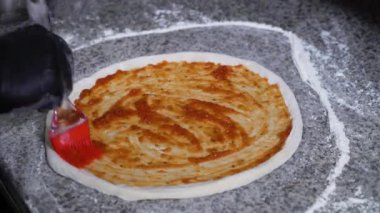 Chef malzemeler üzerinde çiğ hamur pizza yapmak için koyarak eldiven eller. İtalyan pizza el ile üretim. Yemek, yemek, gastronomi kavramı