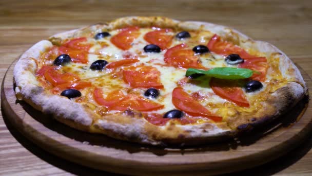 Pizza recién horneada decorada con hojas de albahaca — Vídeo de stock
