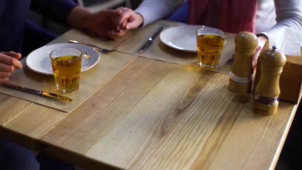 Manos de pareja romántica sentada en la mesa esperando pizza ordenada — Vídeos de Stock