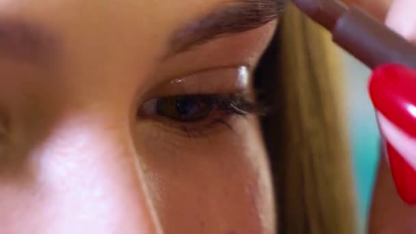 Närbild av kvinnliga makeup artist hand gör ögonbryn form korrigering till kvinnlig modell på skönhetssalong — Stockvideo