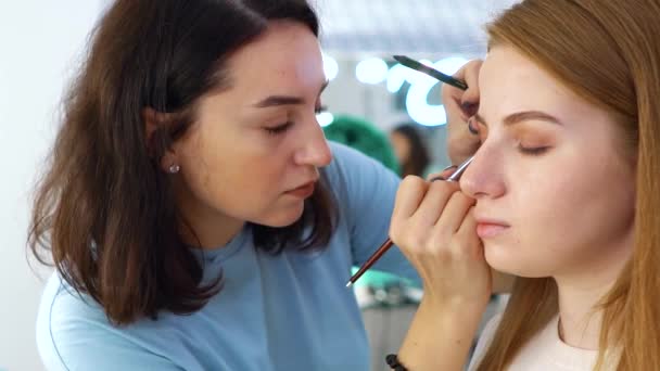 Panning shot de los trabajadores de salón de belleza al servicio de las mujeres clientes — Vídeos de Stock