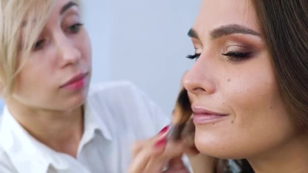 Maquilleur appliquer des cosmétiques sur jeune femme visage gros plan — Video