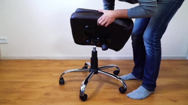 Hombre montaje silla de oficina en casa — Vídeo de stock