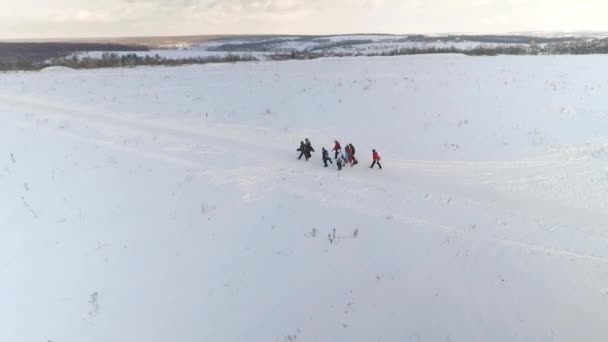 Antenn av gruppen av snowboardåkare med utrustning som går på snö kullar med utrymmet som kopia — Stockvideo