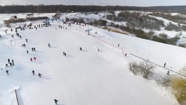 Аеропорт лижників і сноубордистів, які насолоджуються зимовими видами спорту на снігових пагорбах з копією і вільним простором — стокове відео