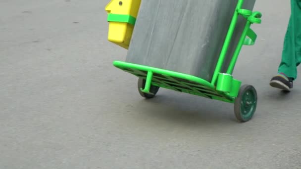 Cleaning service workers in uniform rolling trash bin on wheels in slow motion — Stock Video
