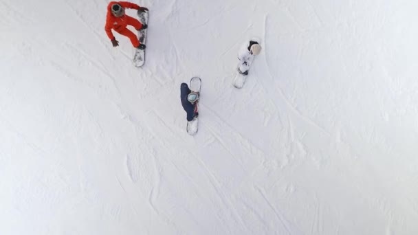 Aerea di gruppo di snowboarder a cavallo lungo il pendio innevato — Video Stock