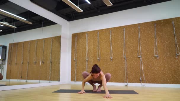 Молода жінка практикує йогу в студії йоги з вільним простором, копіює простір — стокове відео