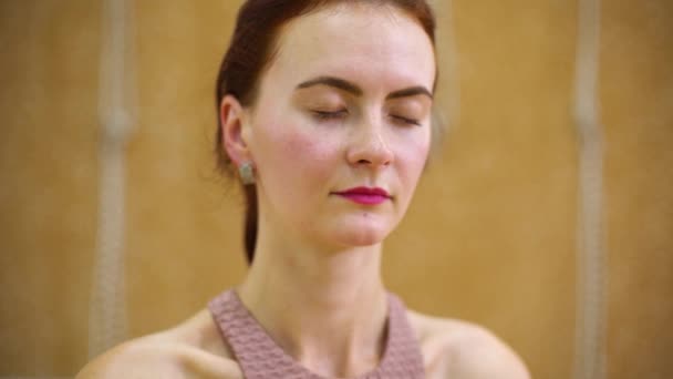 Jonge vrouw mediteert tijdens het beoefenen van yoga in fitness klasse — Stockvideo