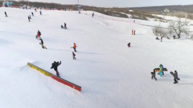 aşağı kayan ve ekipmanları elinde ile karlı yamaç yürürken Snowboard düşkünleri, hava