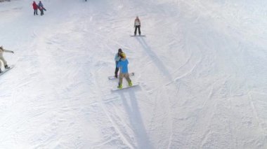 Amatör karlı yamaçta snowboard yardımcı profesyonel snowboarder, hava