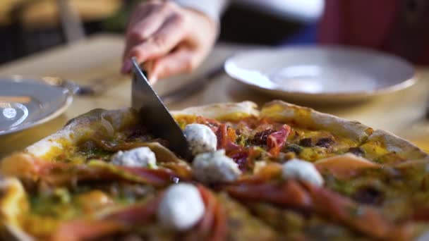 Відрізані скибочки піци і покласти її на тарілки крупним планом — стокове відео