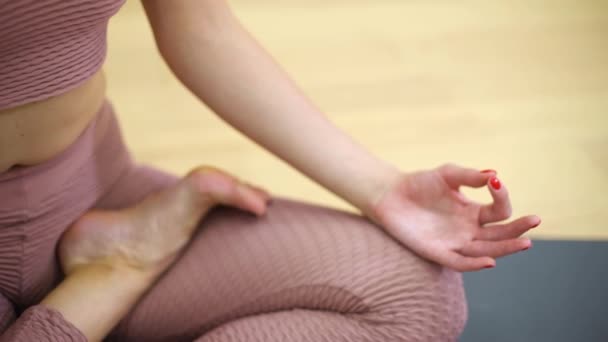 Jonge vrouw in lotus houding zitten en mediteren in fitness klasse met vrije ruimte en kopie ruimte — Stockvideo