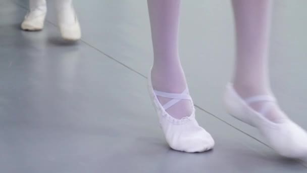 Closeup benen van groepje ballerina's in witte schoenen beoefenen in klassiek ballet studio — Stockvideo