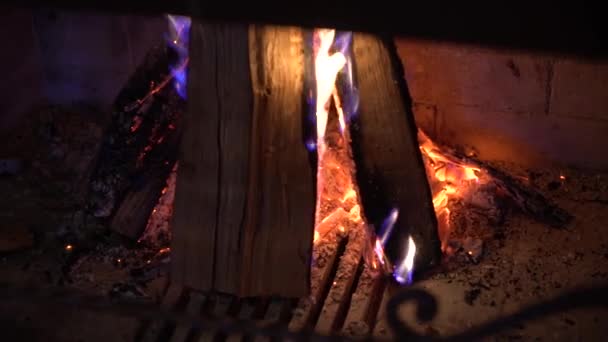 gros plan de bois brûlé dans la cheminée dans l'obscurité 