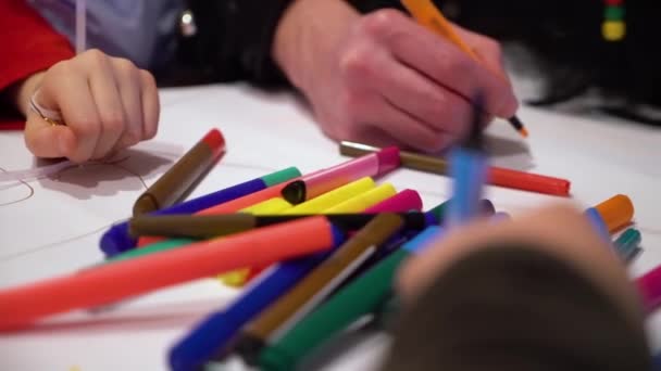 Τα παιδιά της ομάδας closeup μαζί σχέδιο σε χαρτί με έμφαση στην χρωματιστούς μαρκαδόρους — Αρχείο Βίντεο