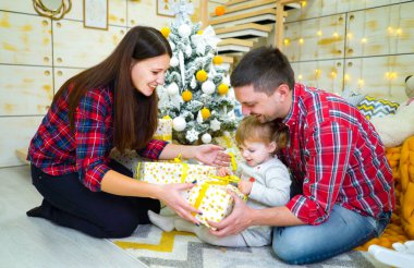 Genç Anne ve yürümeye başlayan çocuk kızı Noel ağacı evde yakınındaki hediye kutuları açma