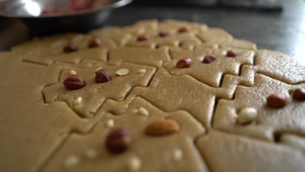 Woman hand adding nuts to raw cookies cut in form of christmas tree closeup — Stock Video