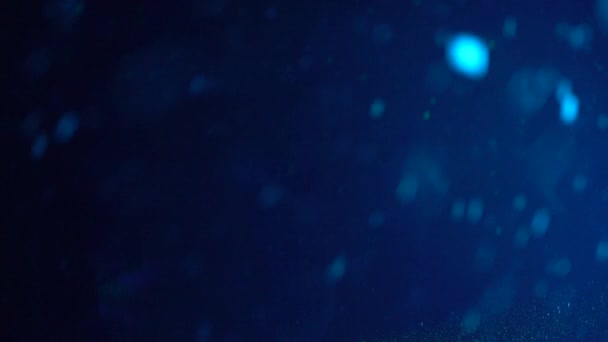 flocons de neige colorés colorés par des projecteurs tombant du ciel dans la forêt d'hiver 