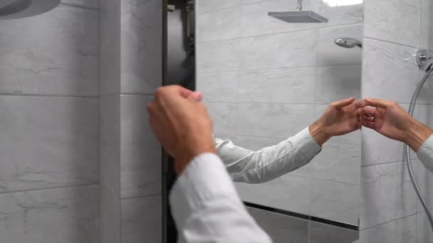 Jeune homme caucasien ouvrir la porte miroir et fermer sur la vanne d'alimentation en eau froide principale — Video