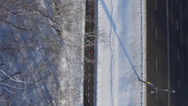 Антенна людей бег по дорожке возле городской дороги в зимний период — стоковое видео